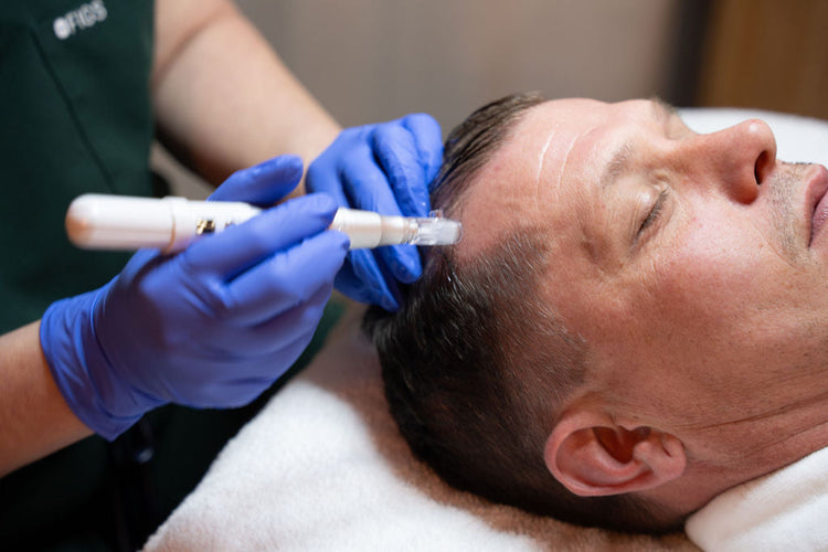 Gloved practitioner uses a pen-shaped treatment device on a person’s scalp.