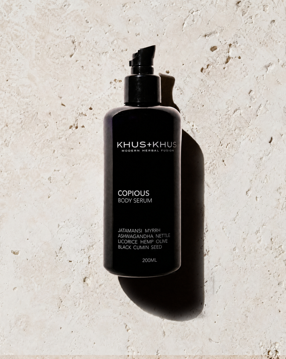 KHUS+KHUS COPIOUS Body Serum 200 mL black pump bottle on a light stone background